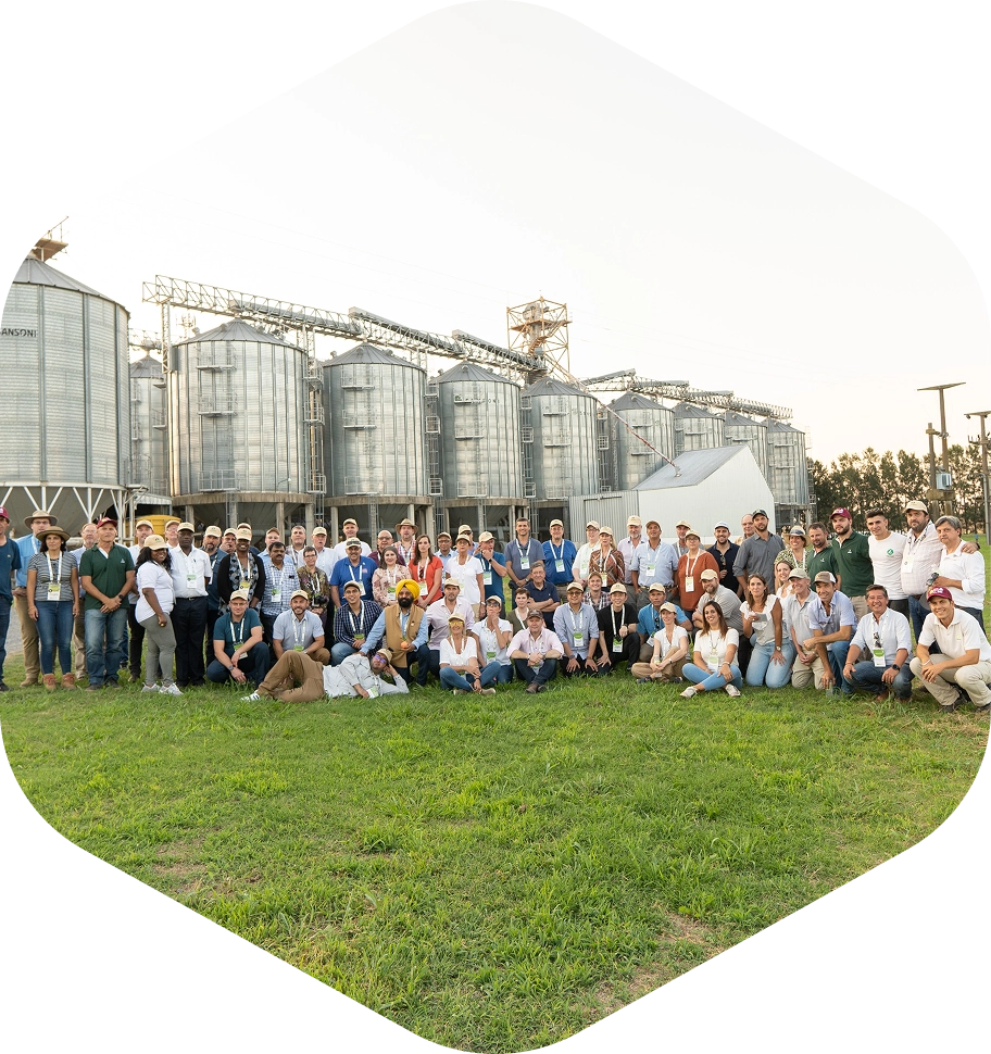 Grupo de participantes en visita técnica al campo argentino con silos de granos
